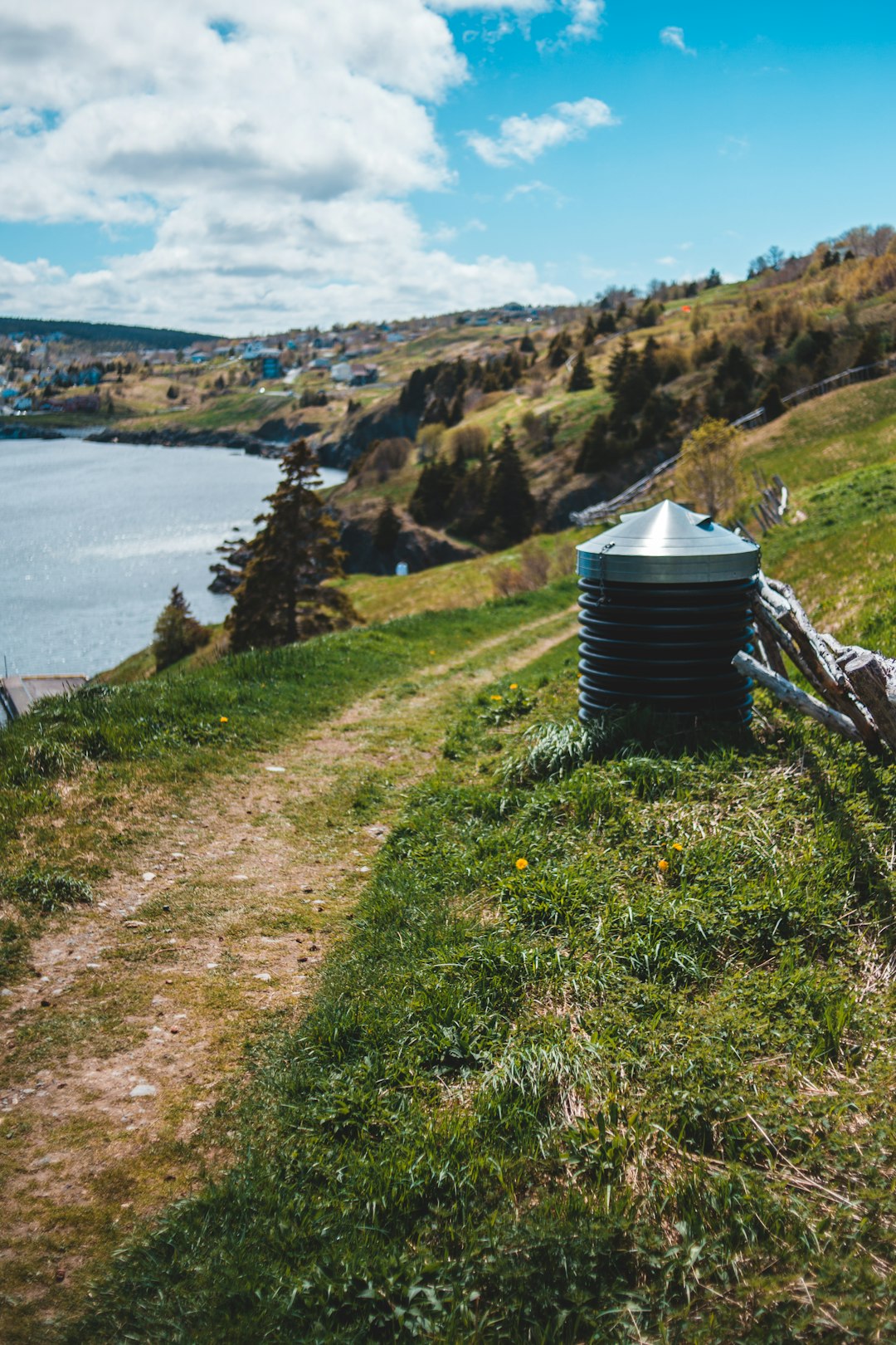 gray steel container on green grass field near body of water during daytime