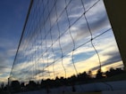 A volleyball net with a bright blue sky in the background