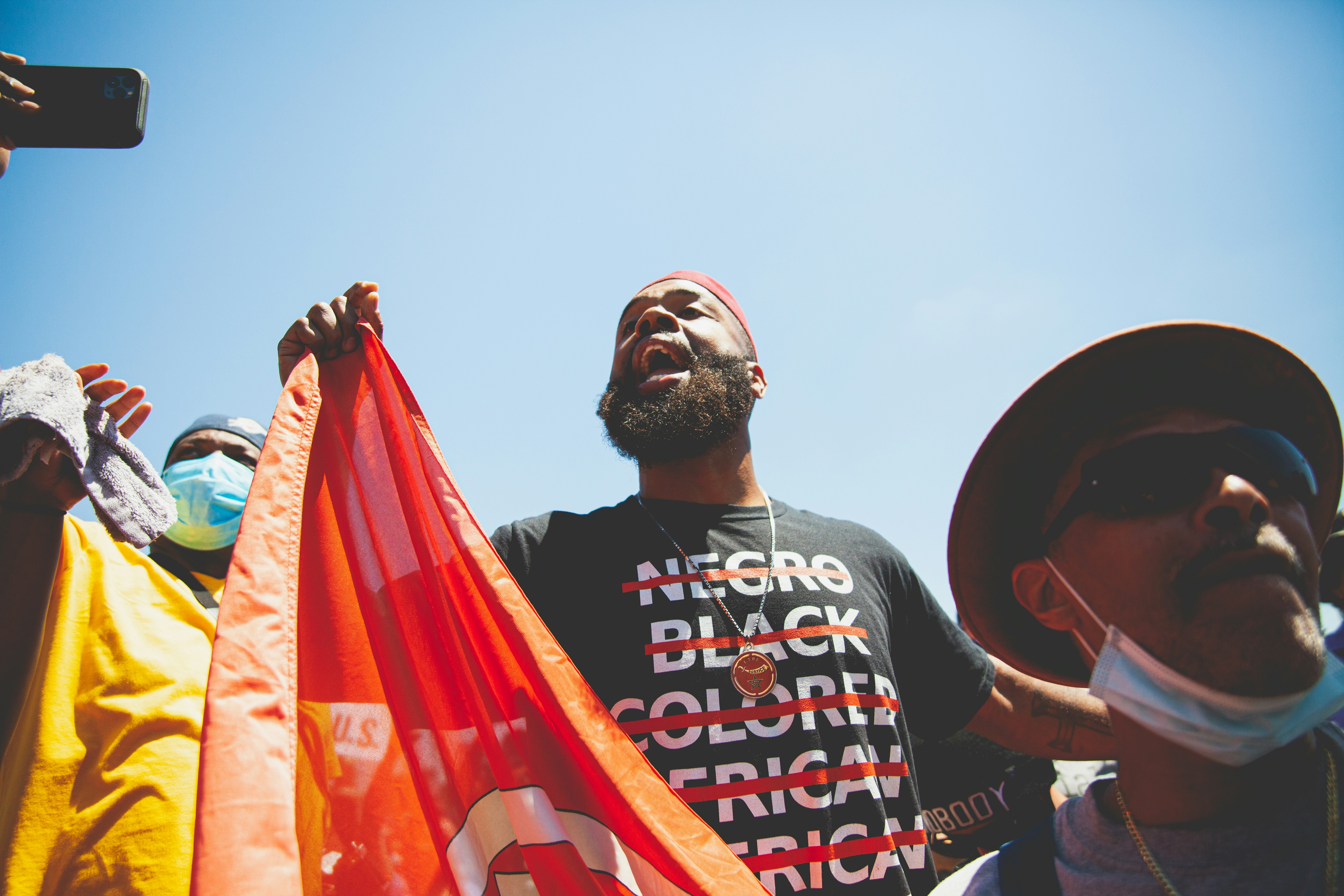 man in black crew neck t-shirt holding red and white flag