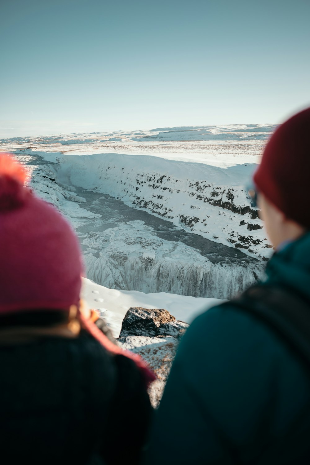 person in red hoodie standing on snow covered ground during daytime