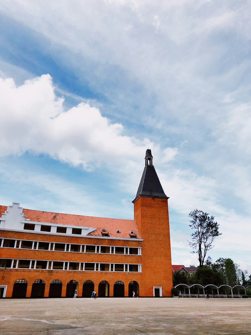 brown concrete building under white clouds during daytime