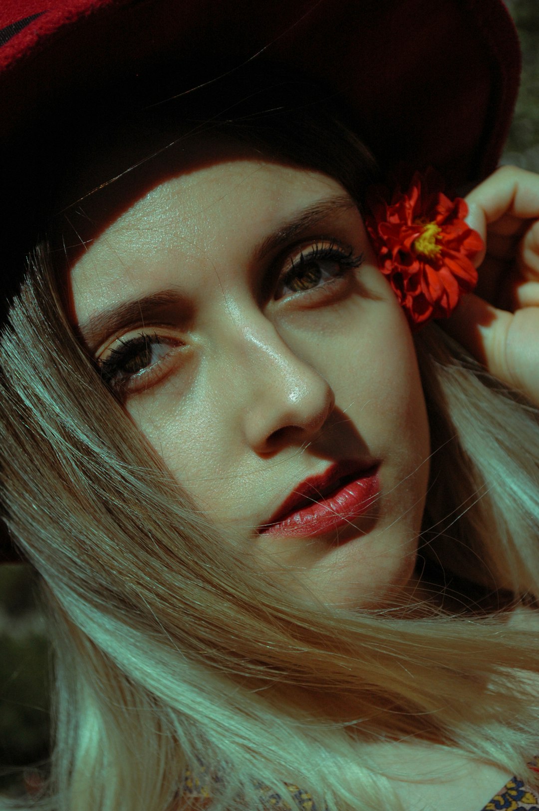 woman with red flower on her ear