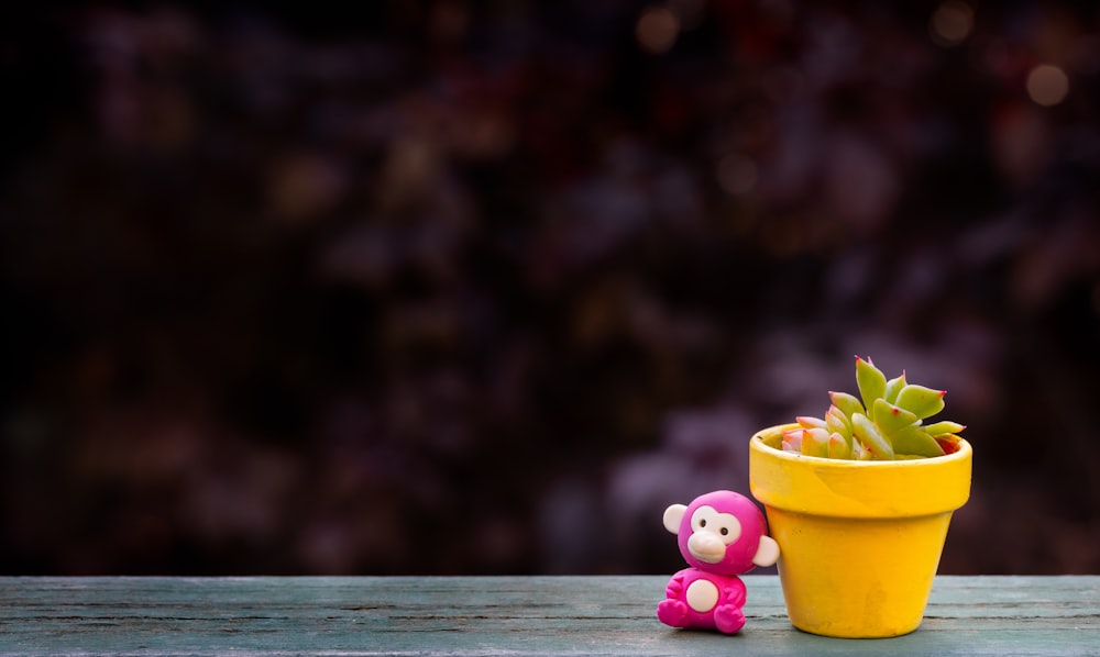 rosa und gelbes Plastikspielzeug auf braunem Holztisch