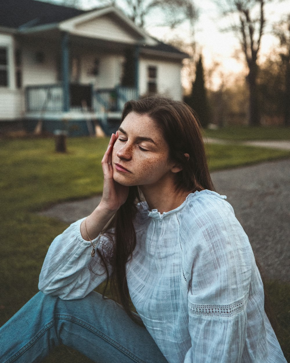 woman in blue denim jacket sitting on green grass field during daytime