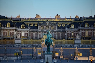 green statue of man riding horse near white building during daytime