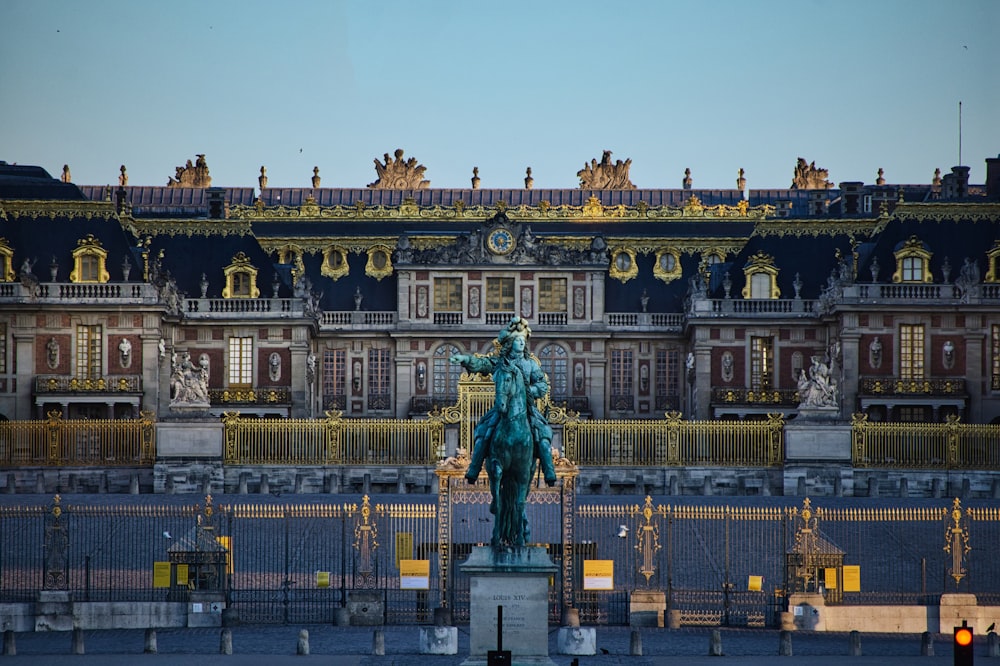 Statue verte d’un homme à cheval près d’un bâtiment blanc pendant la journée