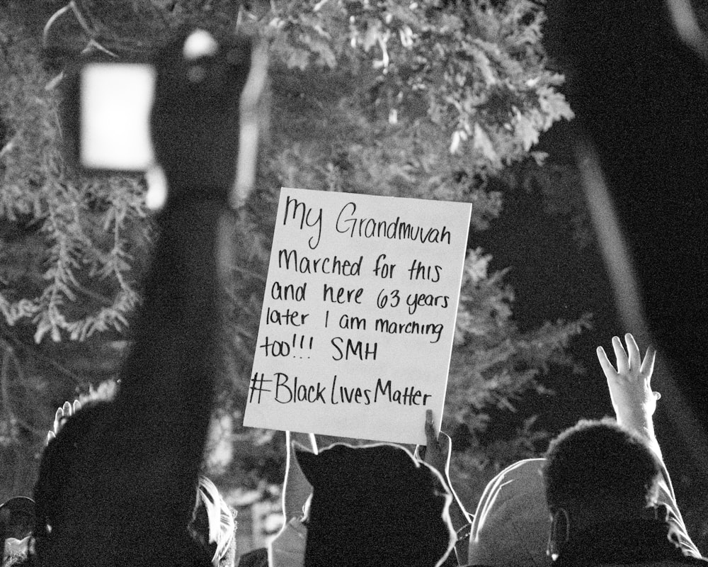 grayscale photo of people holding signage