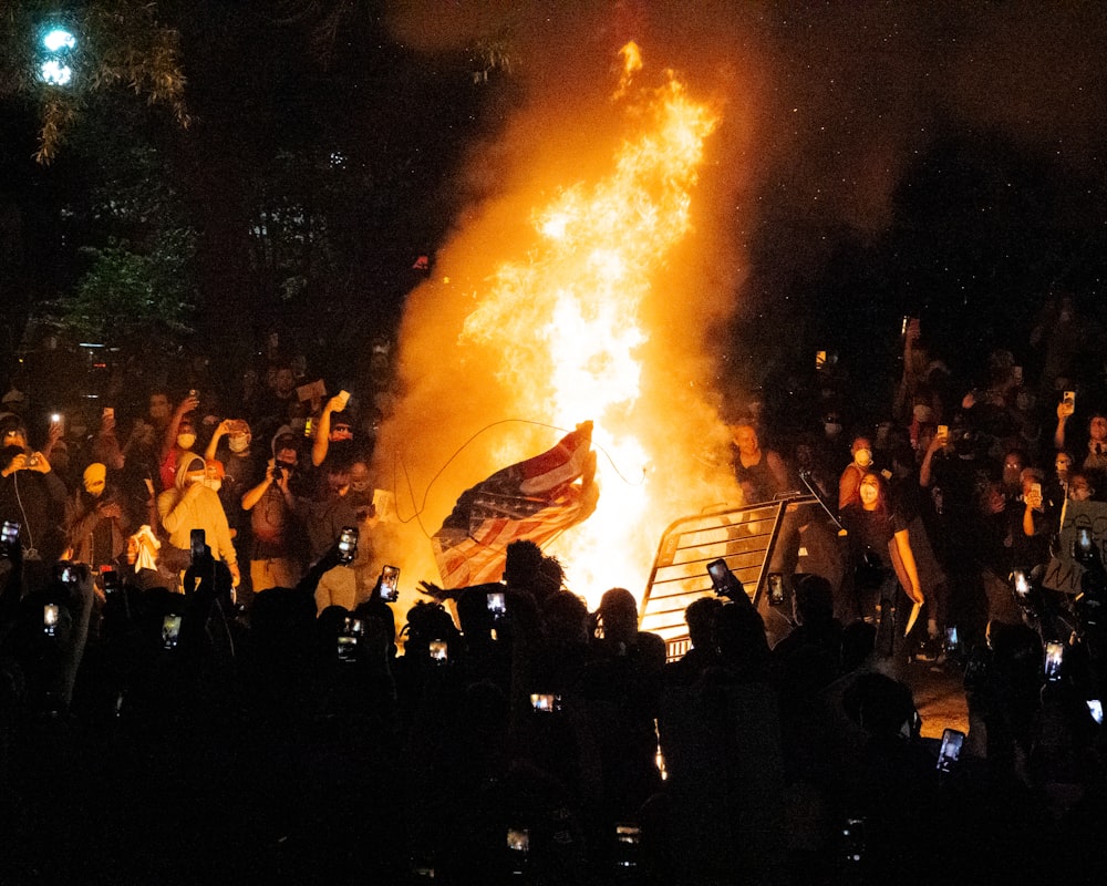 people gathering in front of bonfire during night time