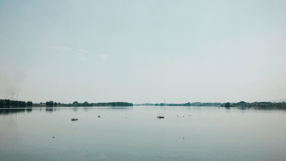 body of water under white sky during daytime