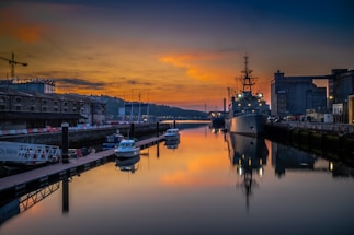 A calm harbor at sunset with cargo ships docked, symbolizing reliable marine logistics.