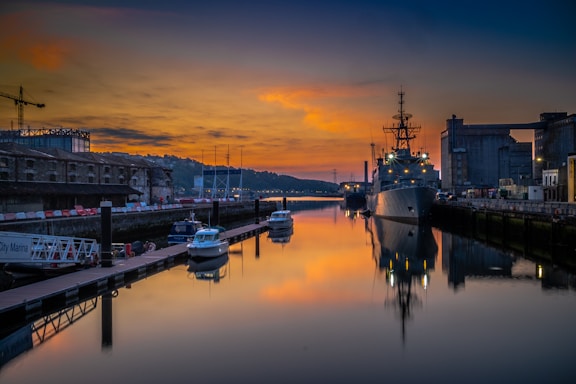 A calm harbor scene at sunset with ships docked, reflecting Adam Shipping's maritime focus.