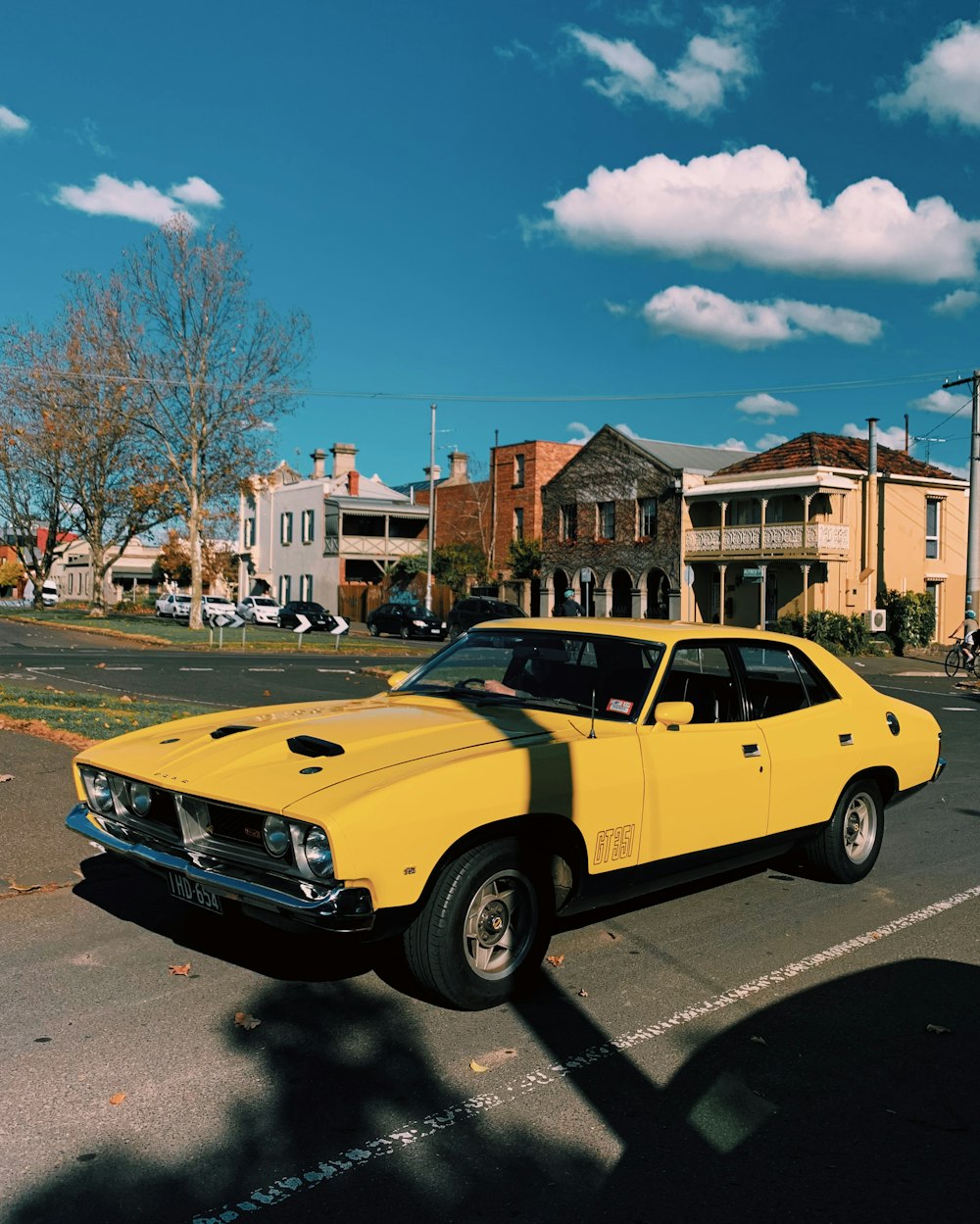 yellow chevrolet camaro parked on roadside during daytime