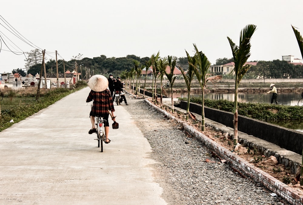 woman in black jacket riding bicycle on gray concrete road during daytime