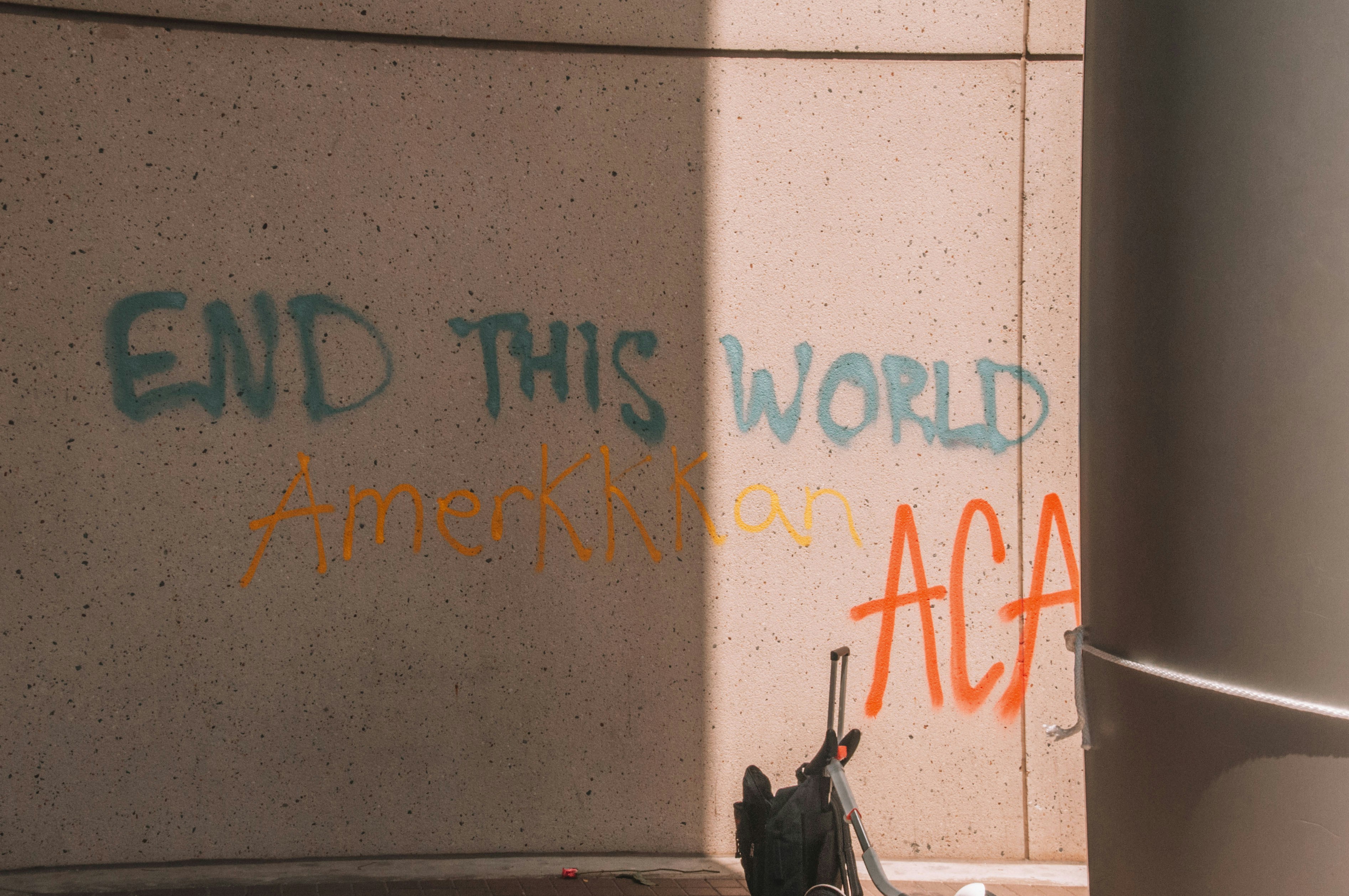 落書きのある壁の脇に駐車された黒いバイク