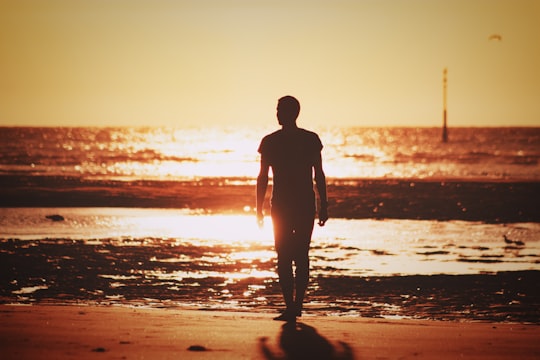 silhouette of man walking on beach during sunset in Dunkerque France