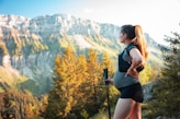 woman in black tank top and black shorts holding black camera standing on brown and green
