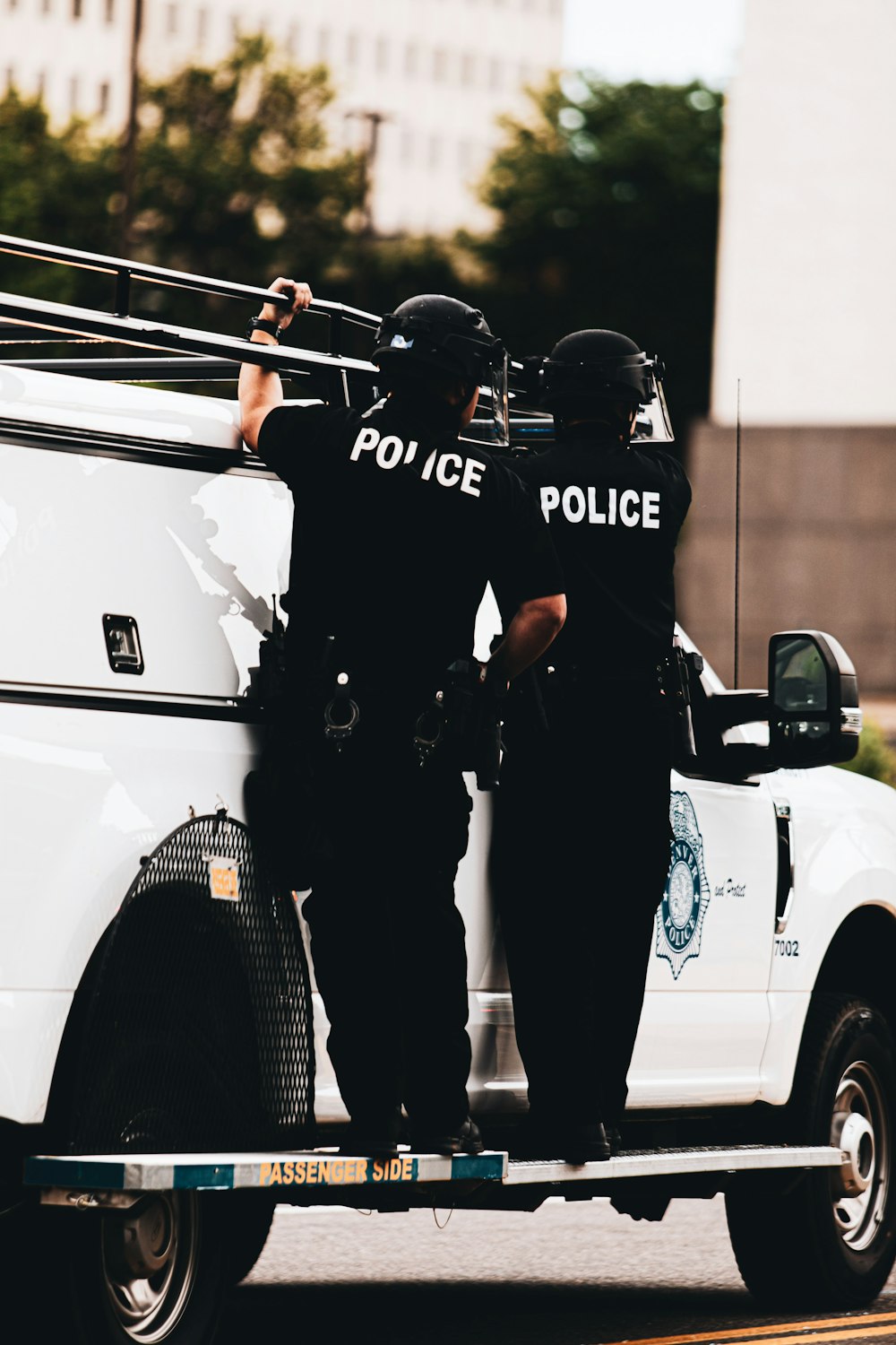 man in black suit standing beside white car