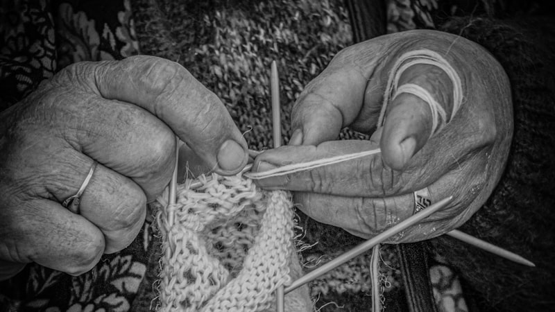 Senior woman knitting with colorful yarn