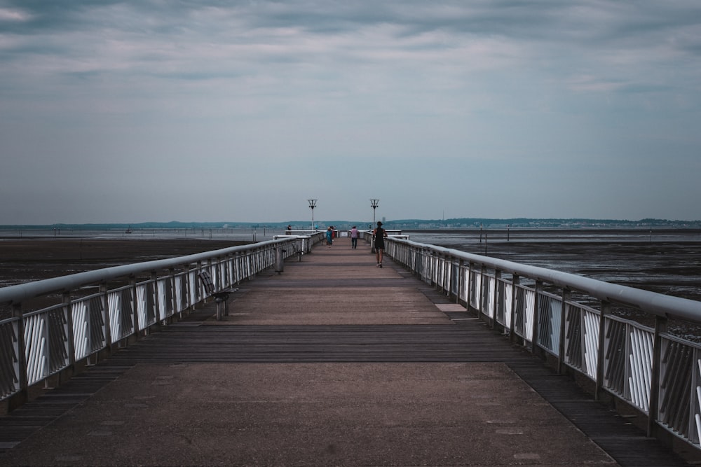 person walking on wooden dock during daytime