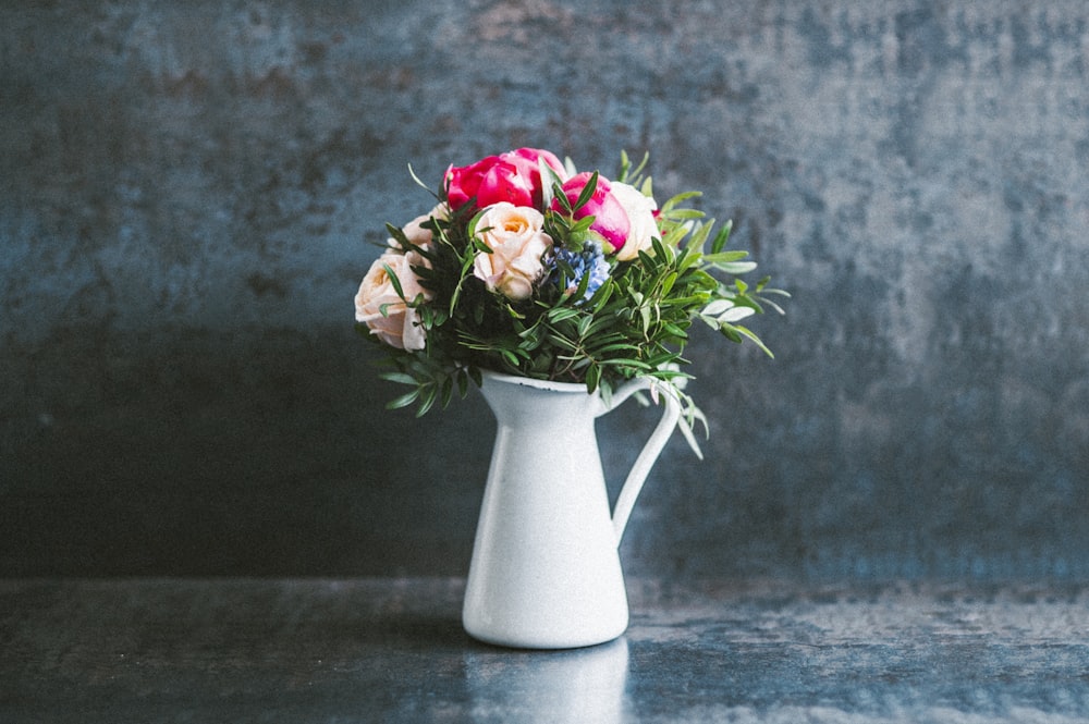 red and white roses in white ceramic vase
