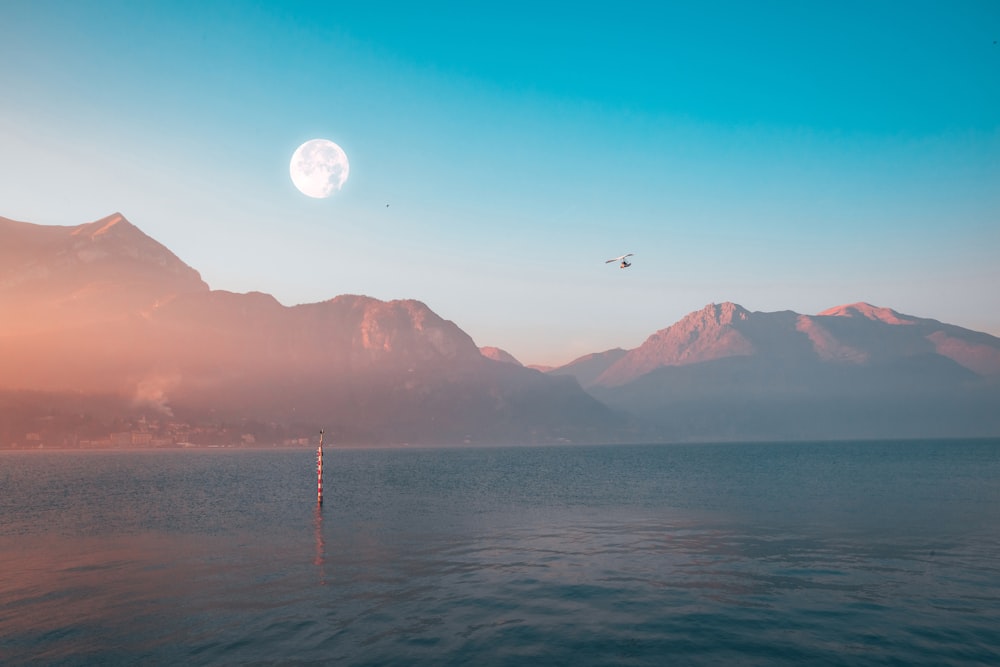 body of water near mountain during daytime