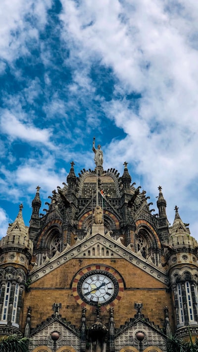 blue and brown concrete church under blue sky and white clouds during daytime