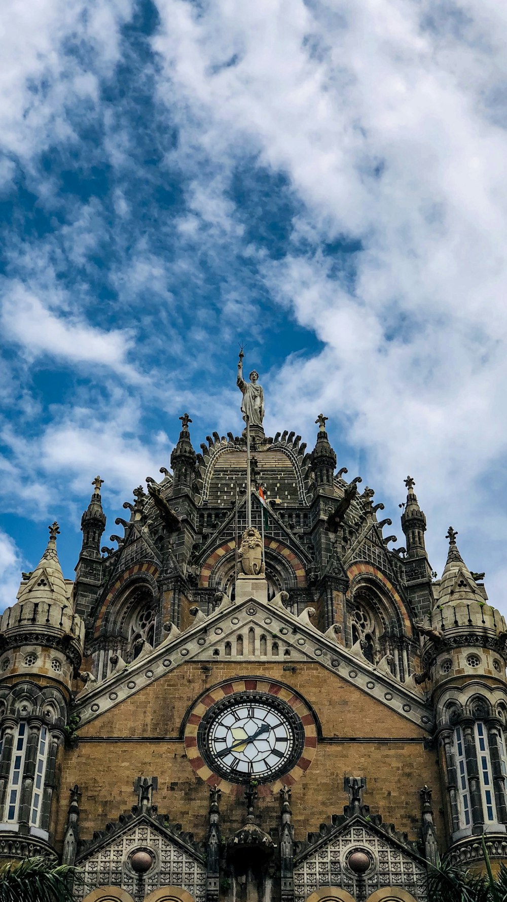 blue and brown concrete church under blue sky and white clouds during daytime