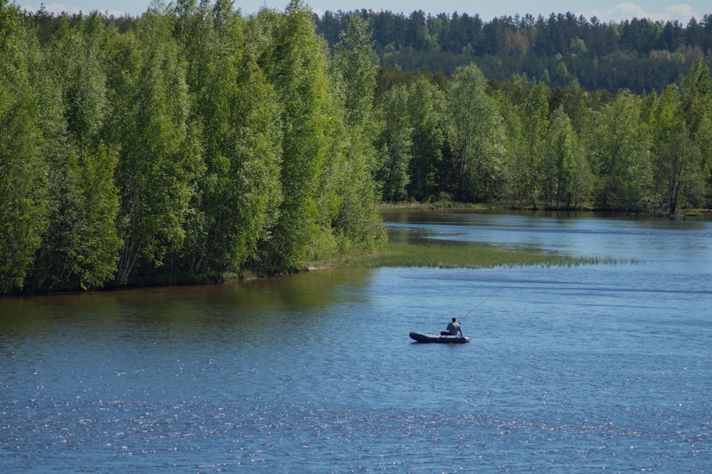 person riding on boat on lake during daytime