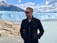 man in black leather jacket standing on gray rock during daytime