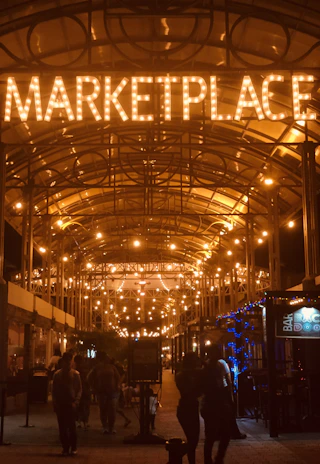 A bustling Anchorway Megamarket storefront glowing under evening lights, inviting customers inside.