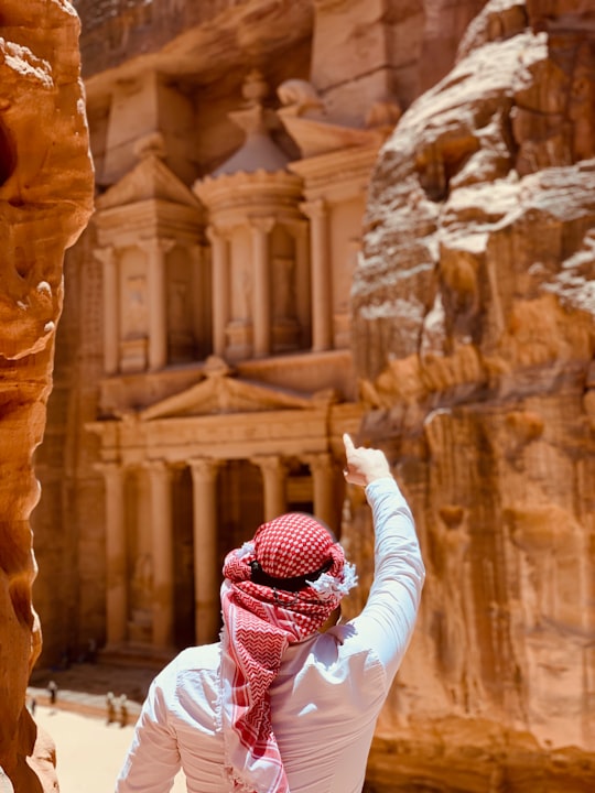 person in white long sleeve shirt and red and white hijab in Petra Jordan