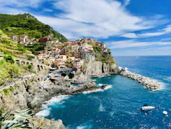 houses on mountain near sea under blue sky during daytime