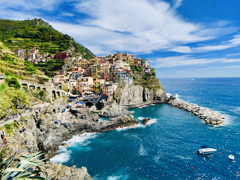 houses on mountain near sea under blue sky during daytime