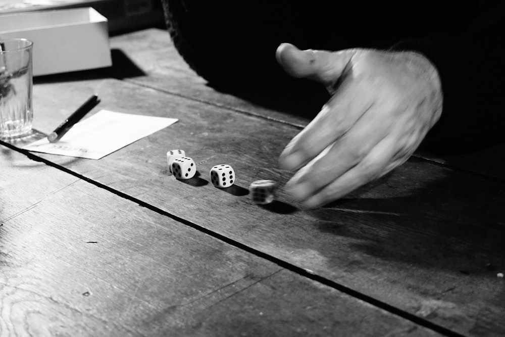 grayscale photo of person holding chess piece