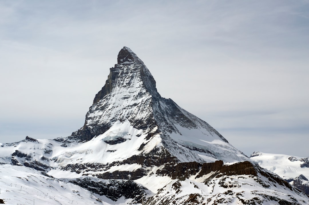 snow covered mountain under cloudy sky during daytime