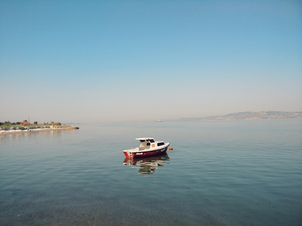 white and red boat on sea during daytime