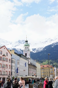white and brown concrete building near mountain under white clouds during daytime
