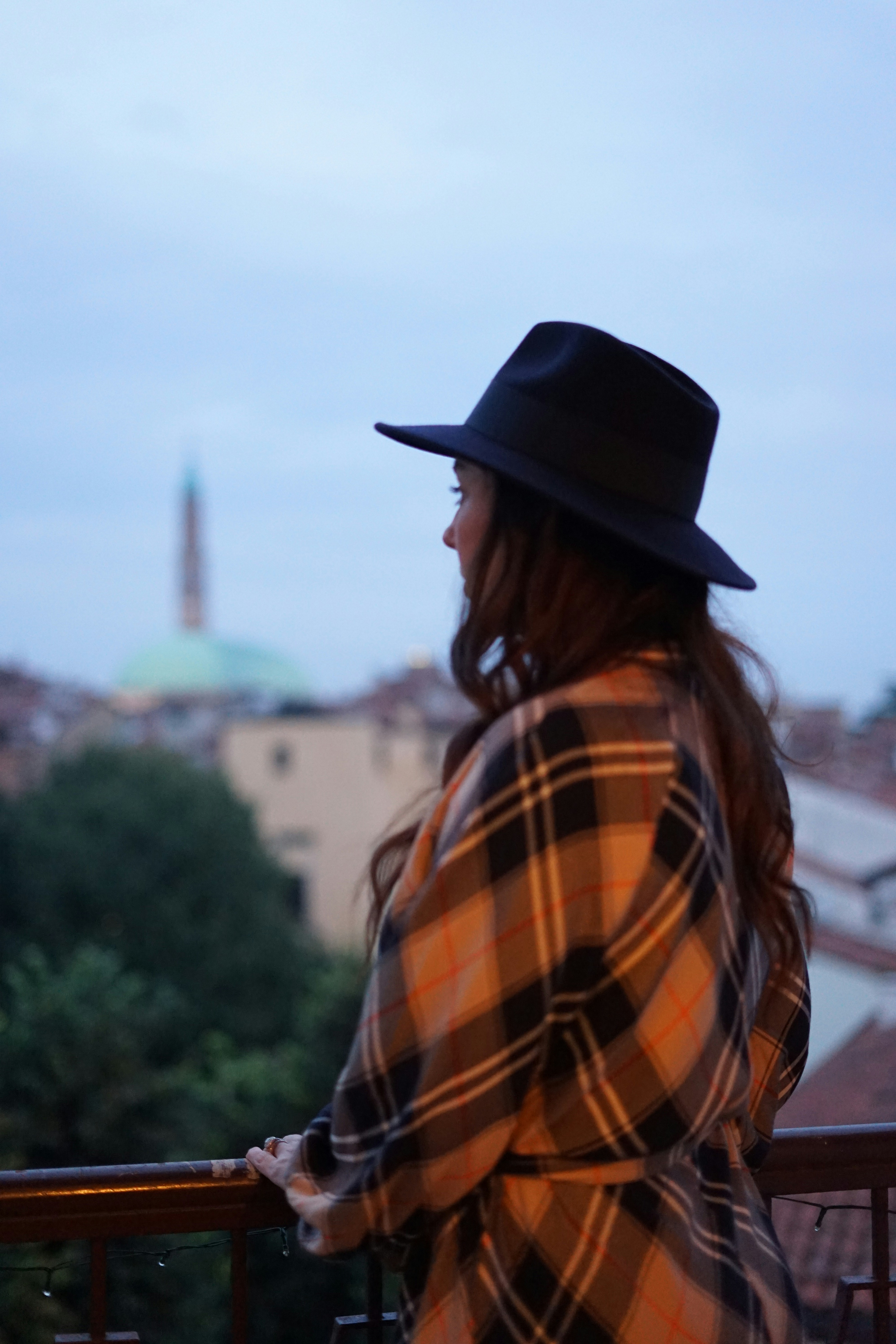 A woman with a hat admiring the view of the city.