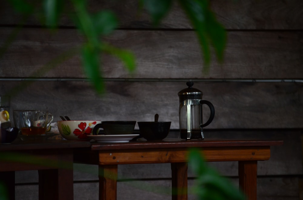 stainless steel pitcher on brown wooden table