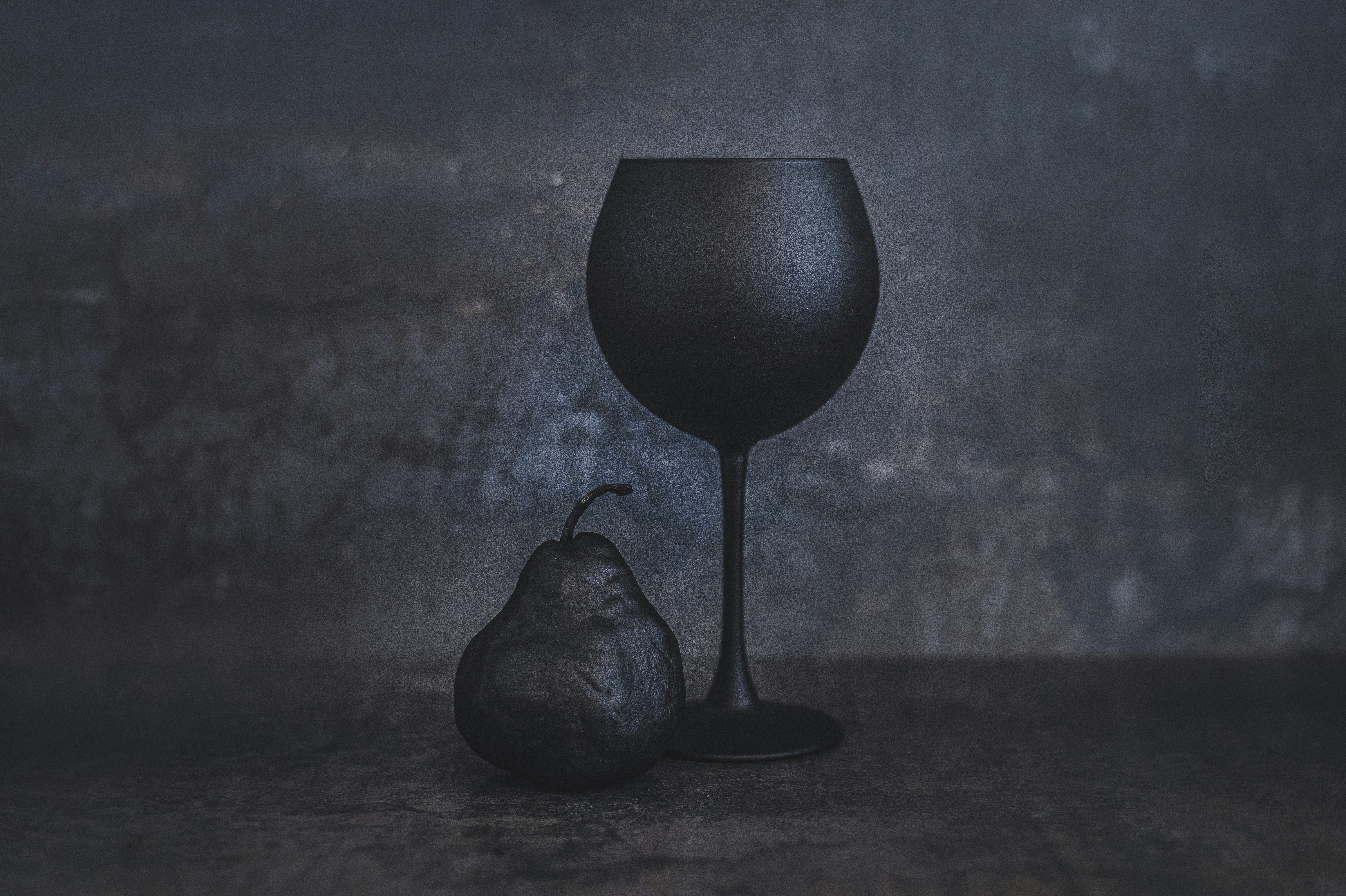 Still life with a black pear and a glass.