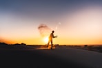 silhouette of man running on sand during sunset