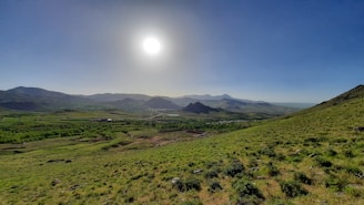 A serene mountain landscape under a bright blue sky.