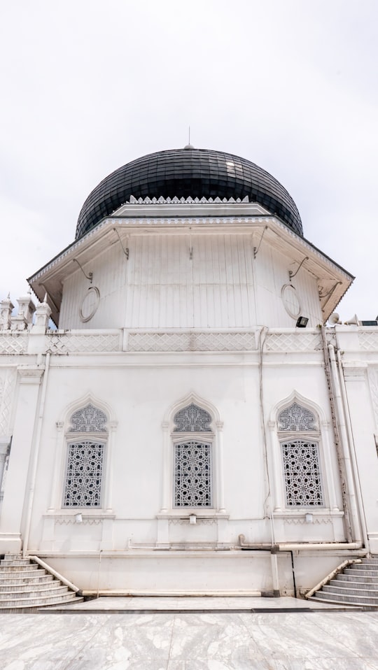 white concrete building during daytime in Baiturrahman Grand Mosque Indonesia