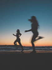 Dynamic shot of a man and woman jogging at sunrise, showcasing energy and performance.