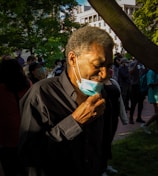 man in black jacket holding white plastic bag