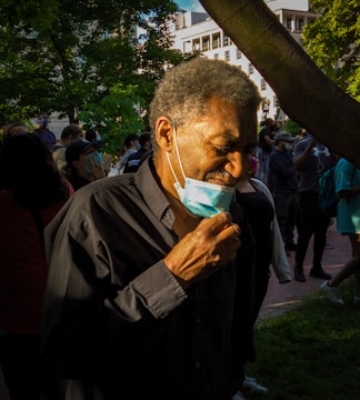 man in black jacket holding white plastic bag