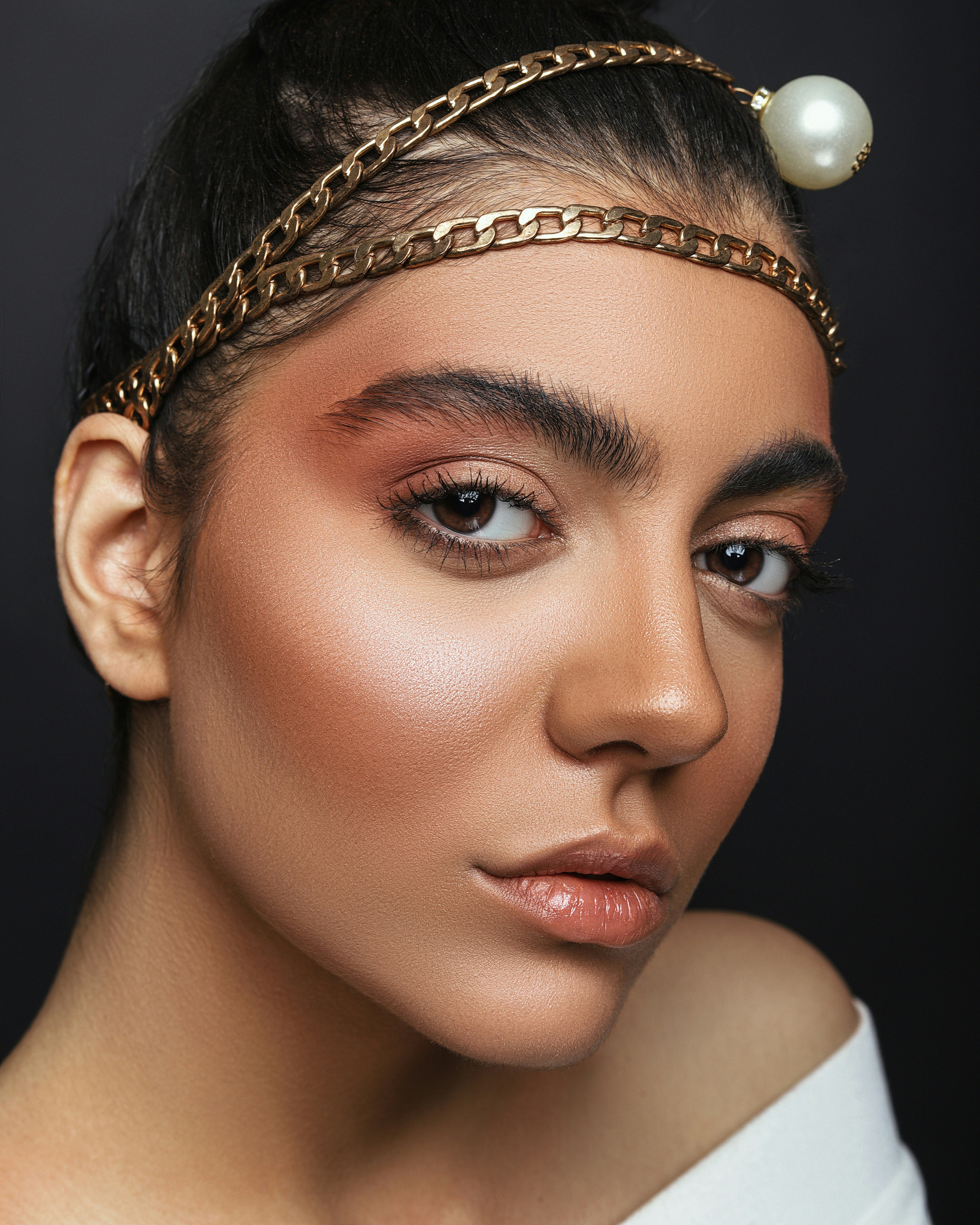 woman wearing gold crown and white pearl necklace