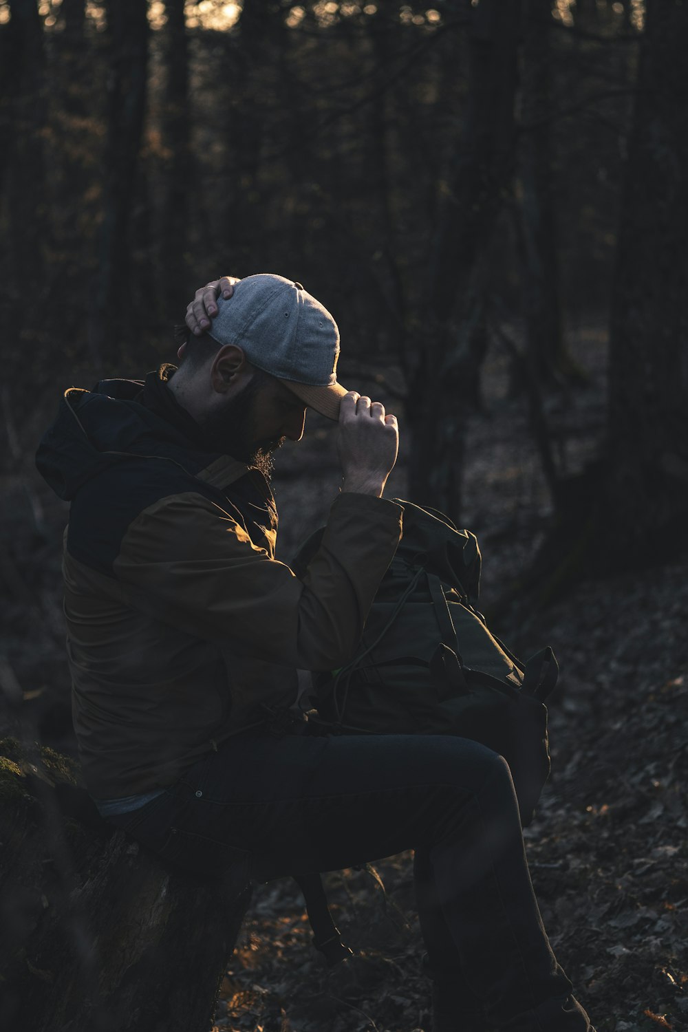 woman in black jacket and black pants sitting on rock