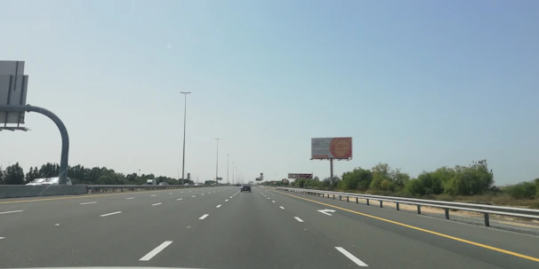 A busy Indian highway with diverse vehicles and clear road signs under a bright sky.