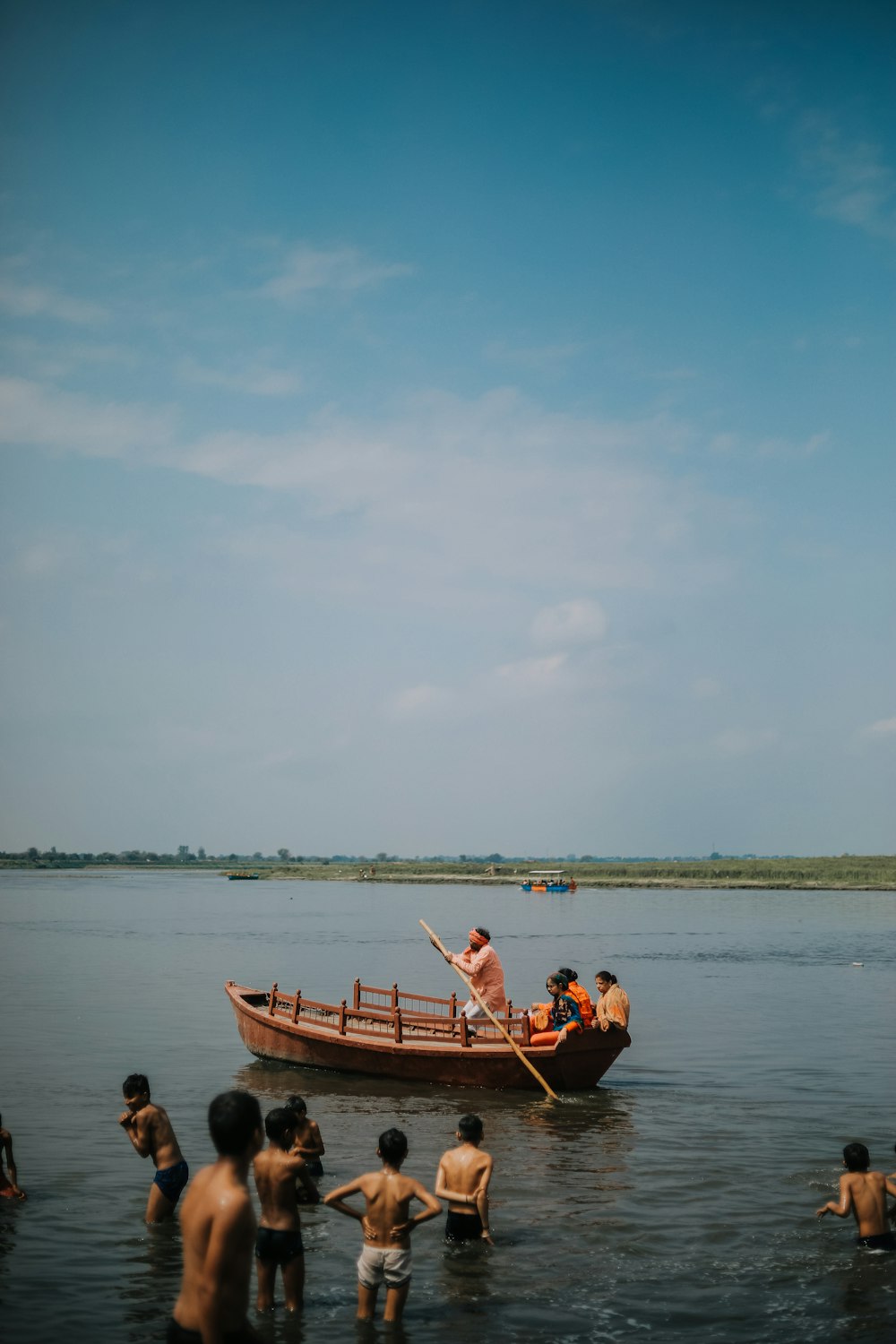 2 men and woman riding on brown boat on sea during daytime